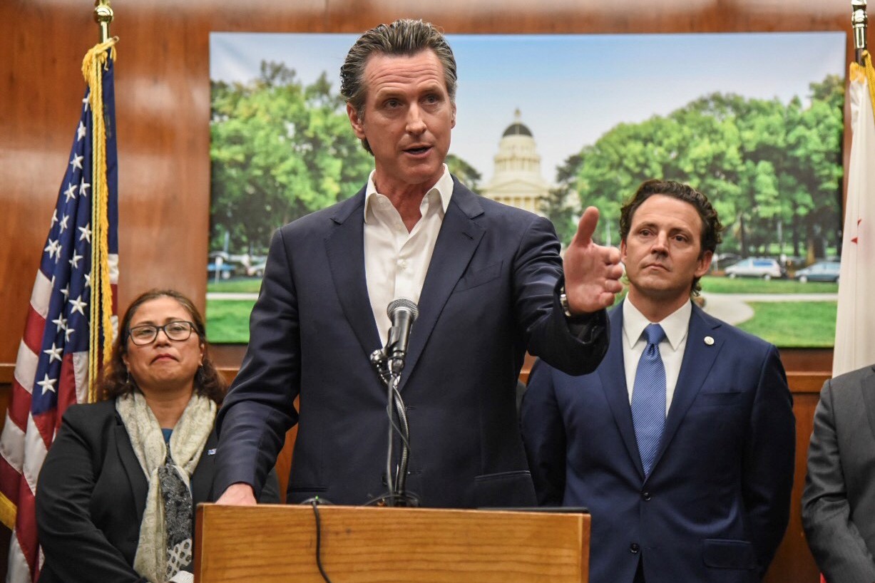 Governor Newsom speaks from a podium.