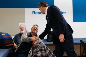 Governor Newsom shakes hands with an individual at the center in Riverside. 