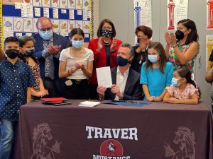 Governor Newsom signs legislation next to students