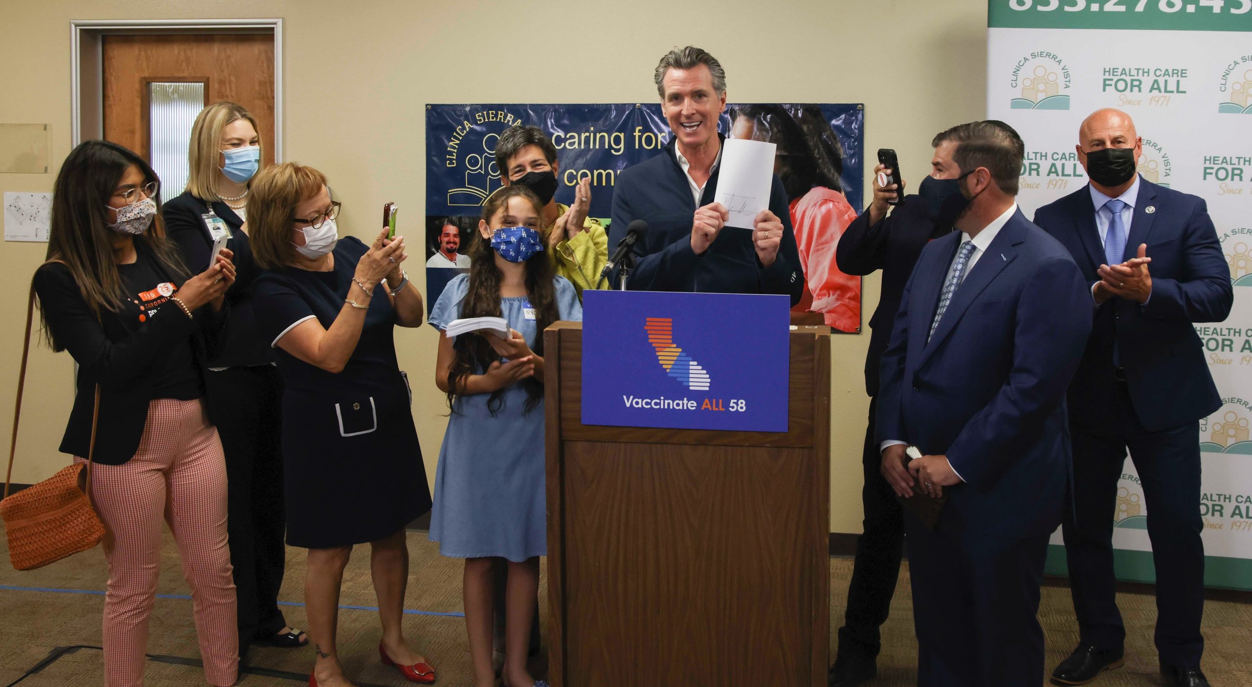 Governor Newsom holds up health trailer bill at signing ceremony 