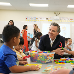Governor talking to children in a classroom.