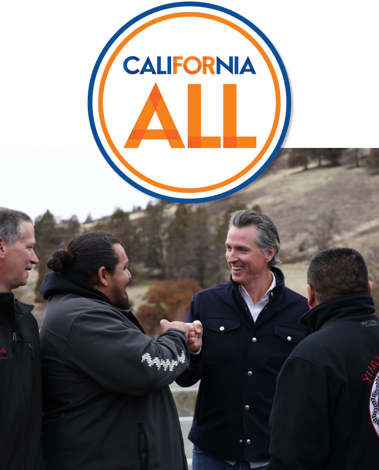 California for all logo. Outside in a rural area with hills and tress, Governor Newsom fist bumps and smiles at a man from a native Californian tribe.