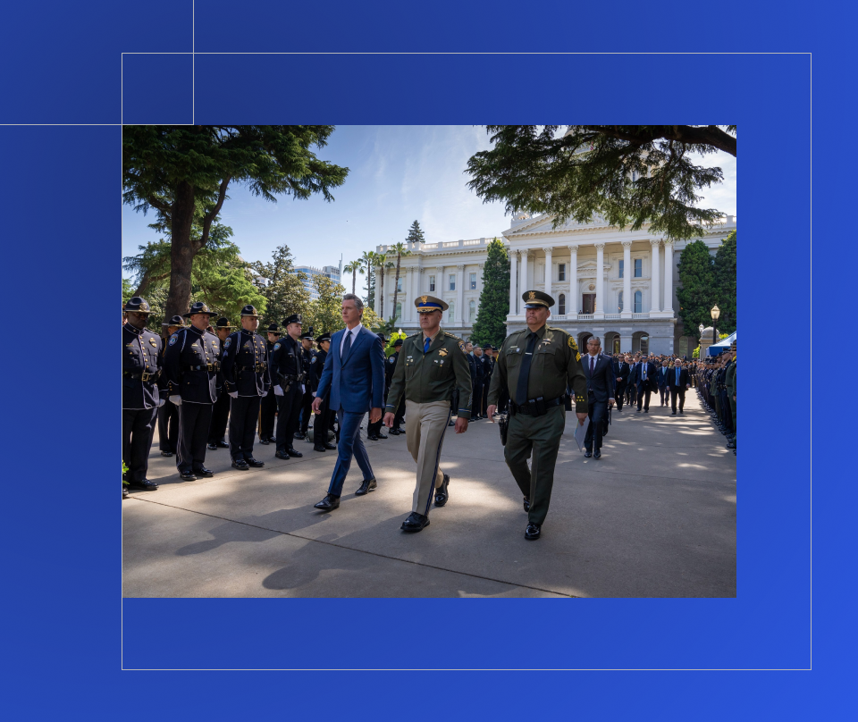 Governor walking with police officers near the State Capitol.