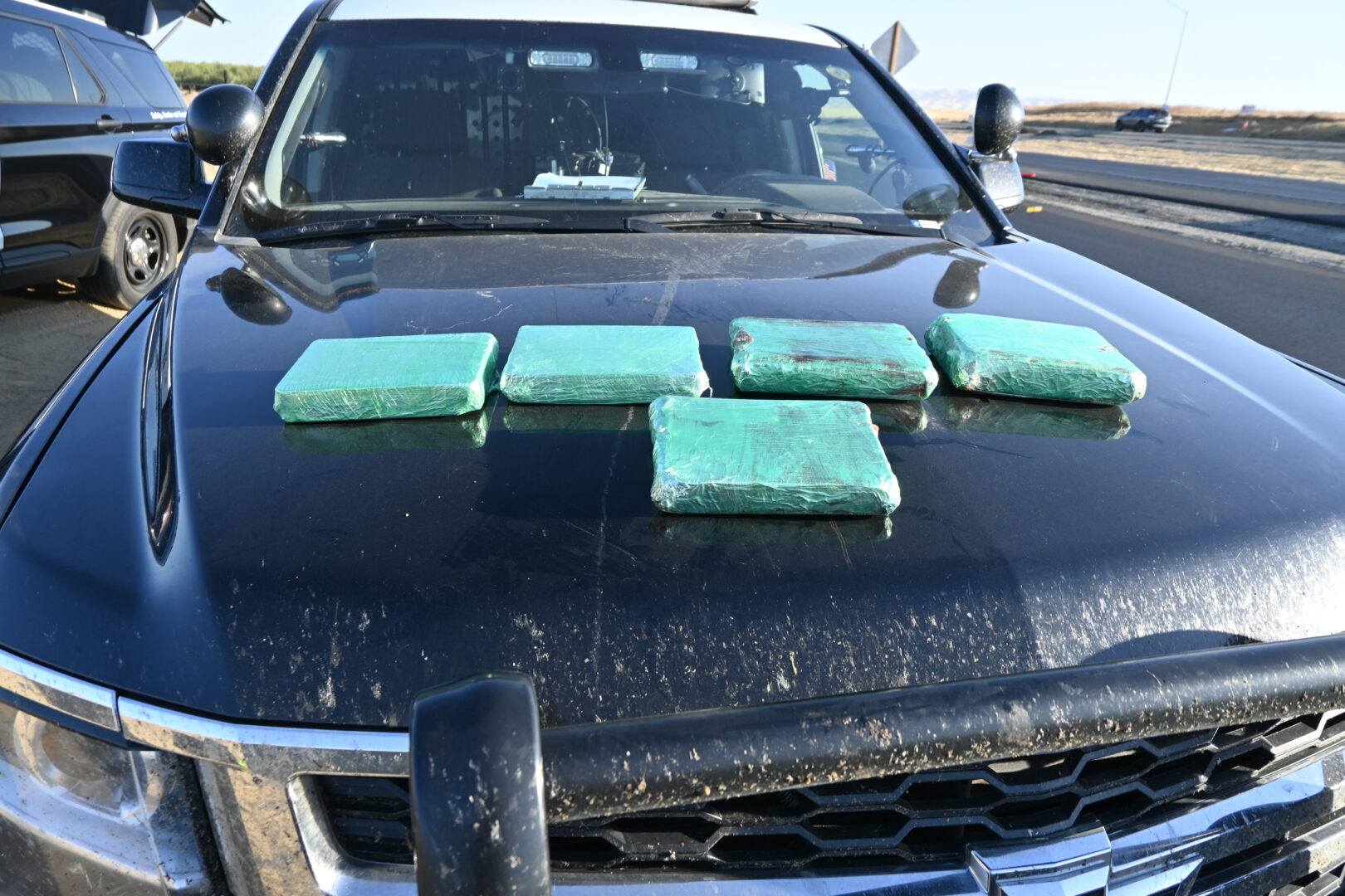 Image of police vehicle with 5 packets of fentanyl on the hood