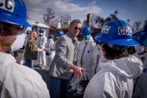 A photo of Governor Newsom and First Partner Siebel Newsom shaking hands with California Conservation Corps members who were installing protective measures ahead of an incoming storm.