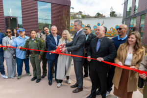 A photo of Governor Newsom and others cutting a ribbon at the San Quentin Learning Center
