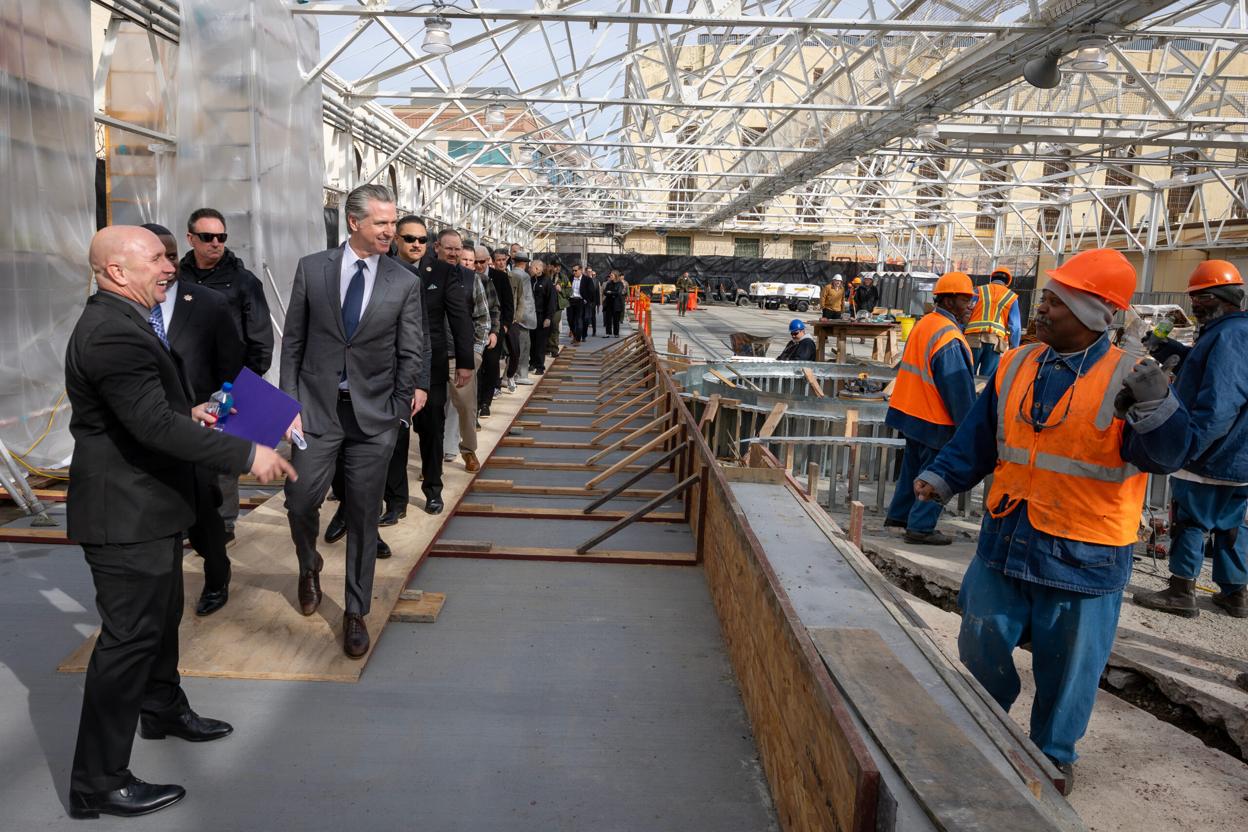 A photo of Governor Newsom walking through the San Quentin upper yard construction