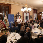 A photo of Governor Gavin Newsom speaking to a group of people