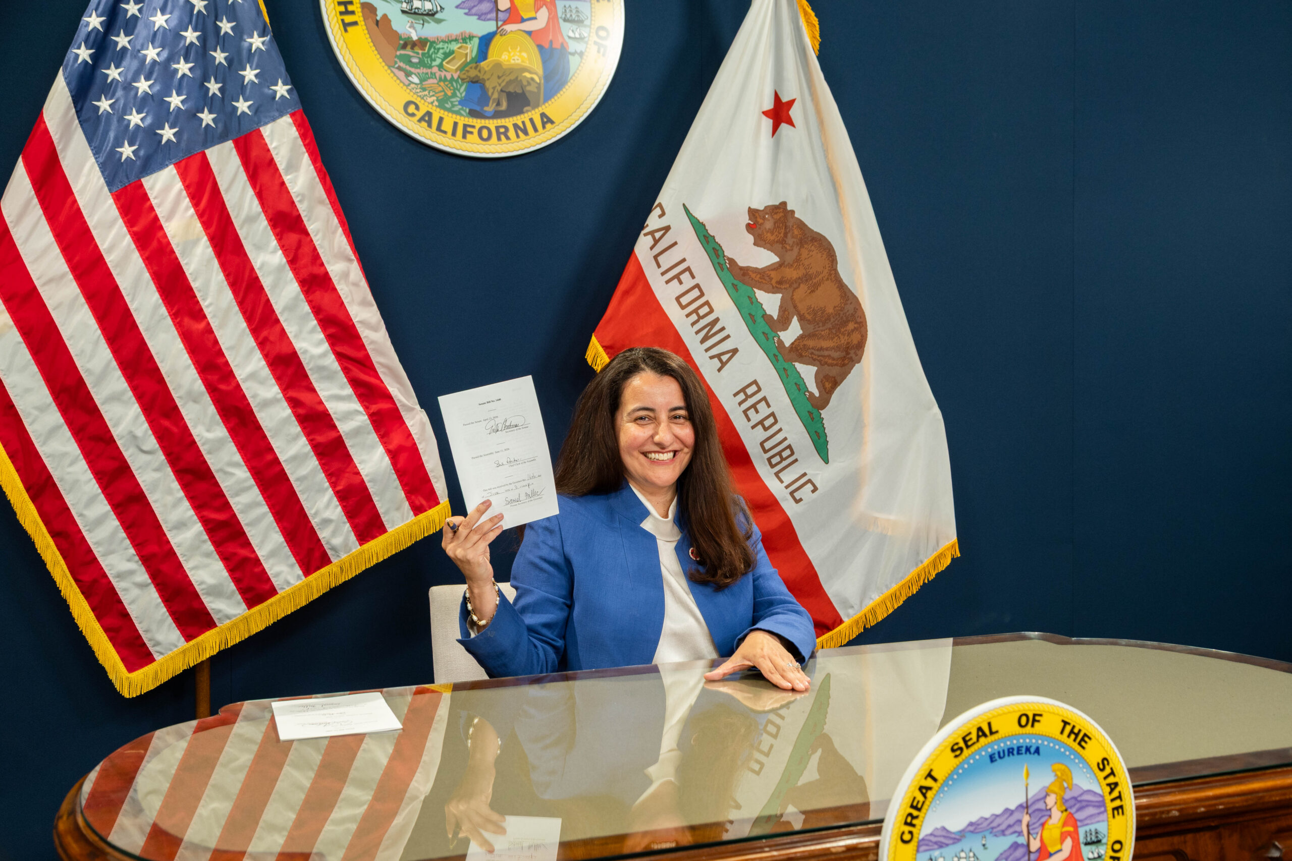 Acting Governor Monique Limon holding a signed bill/