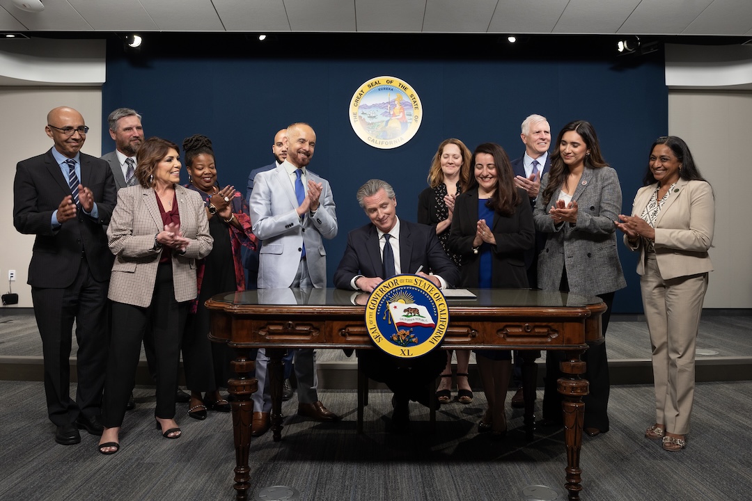 Governor Newsom alongside state legislators as he signing SB 417