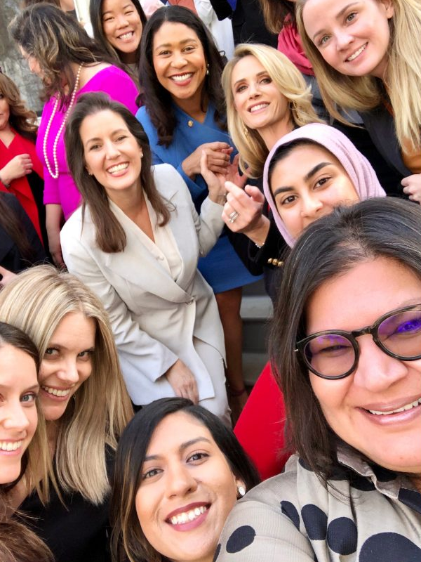 First Partner Jennifer Siebel Newsom is in a group selfie shot. With her is a diverse group of women of varying ethnicities and ages.